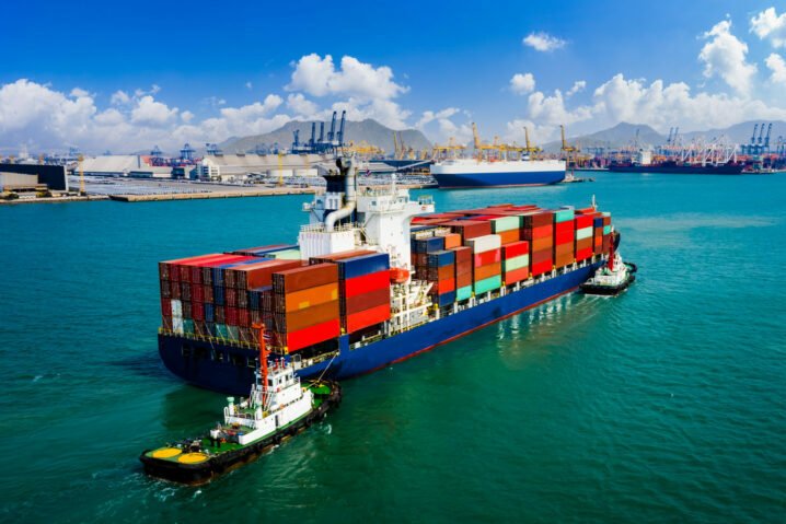 Container,Ship,Sailing,In,Green,Sea,And,Tugboat,Drag,Shipping